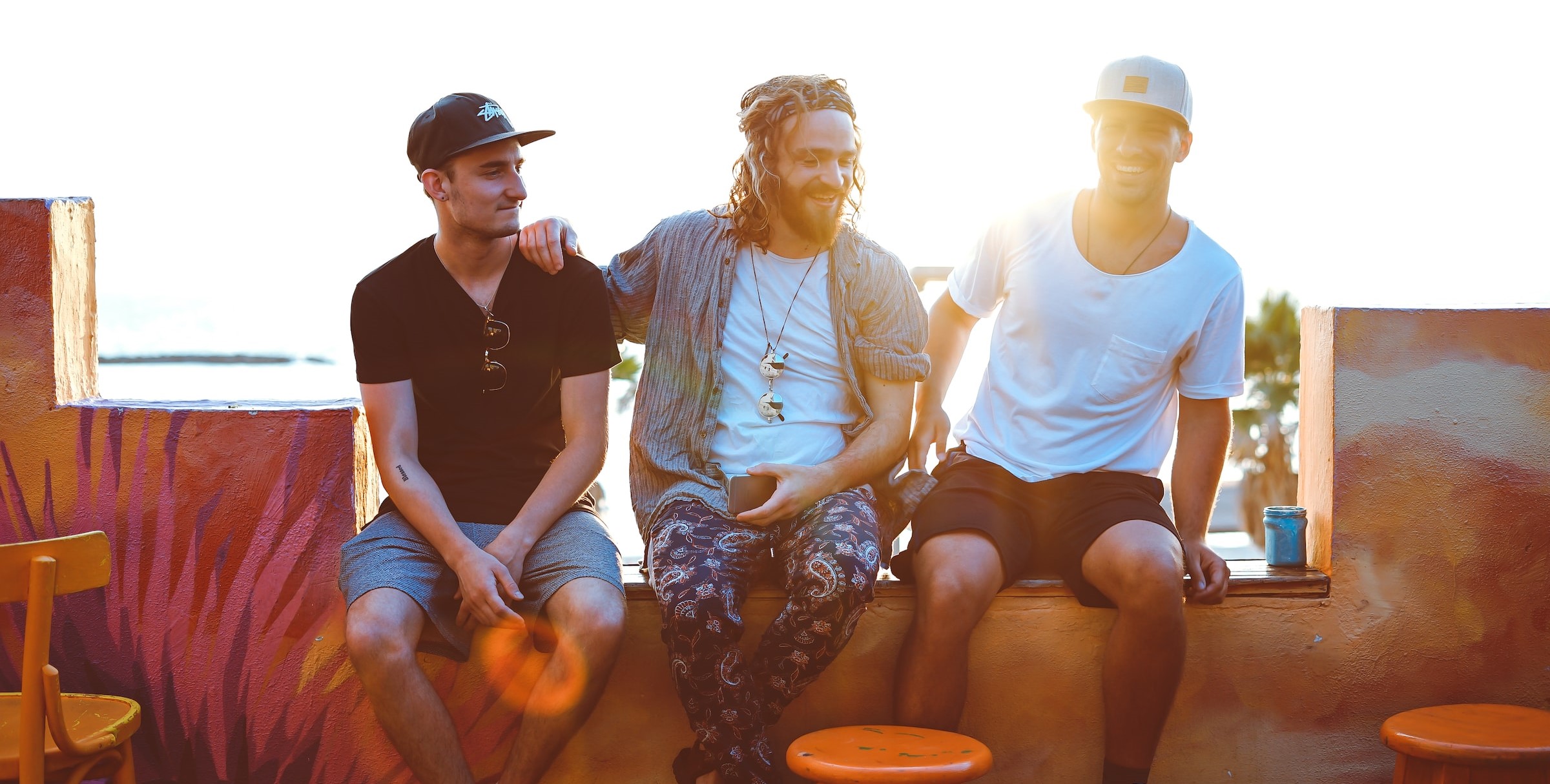 Three men sitting in a cafe talking about their sexual health